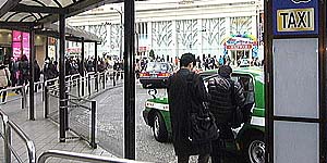 駅前のタクシー乗り場で付け待ち（駅付け）営業しているタクシーにお客様が乗車しようとしている写真